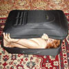 a girl fits herself into small suitcase