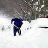 man is looking for his car covered by snow