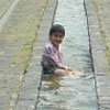 poor kids having a bath in a drain