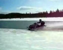 dude crosses unfrozen river on his snow mobile.