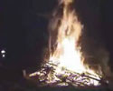 video of a guy almost jumps over large bonfire.