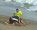 guys are fighting on the beach. Small one gets owned.