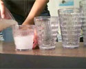 pouring milk into several glasses in trick video